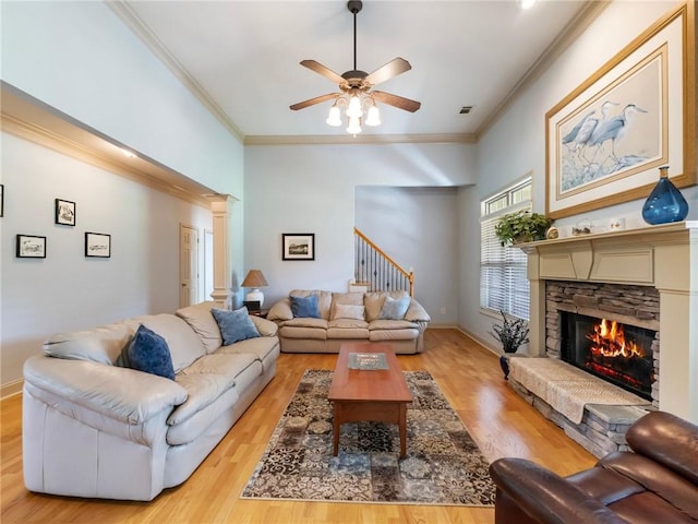 11 Stillwater Way, Hoschton, GA 30548 - living room with a fireplace, a ceiling fan, light wood-type flooring, ornamental molding, and stairway