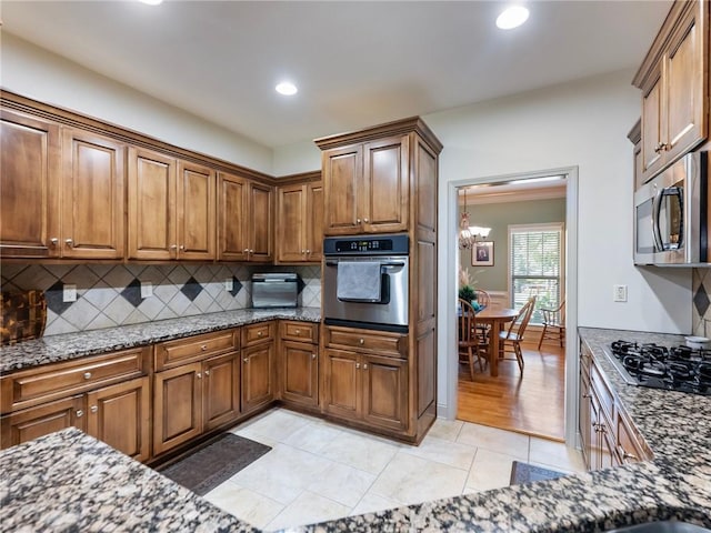 11 Stillwater Way, Hoschton, GA 30548 - kitchen featuring appliances with stainless steel finishes, a chandelier, dark stone countertops, tasteful backsplash, and recessed lighting