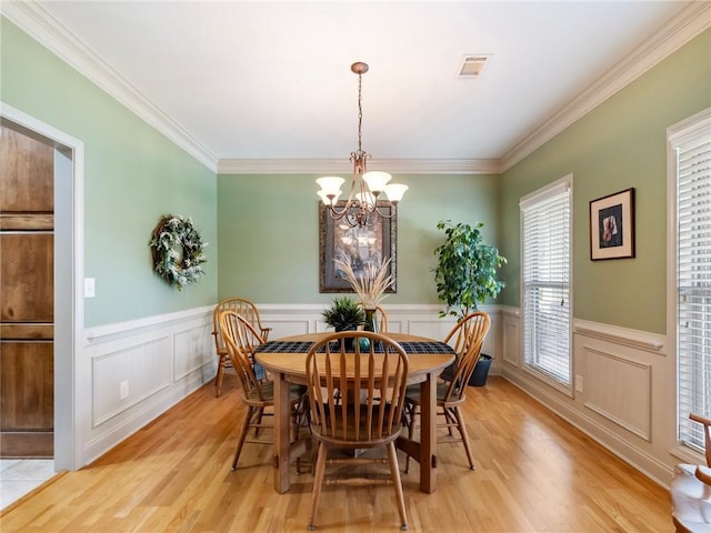 11 Stillwater Way, Hoschton, GA 30548 - dining area featuring a chandelier, light wood-type flooring, a wainscoted wall, ornamental molding, and a decorative wall