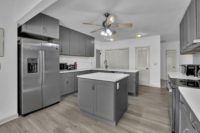 kitchen featuring gray cabinetry, ceiling fan, light hardwood / wood-style flooring, a kitchen island, and appliances with stainless steel finishes