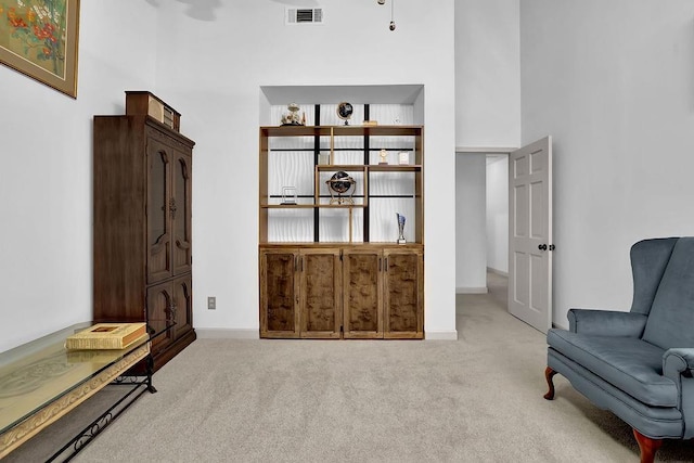 sitting room with light carpet and a high ceiling