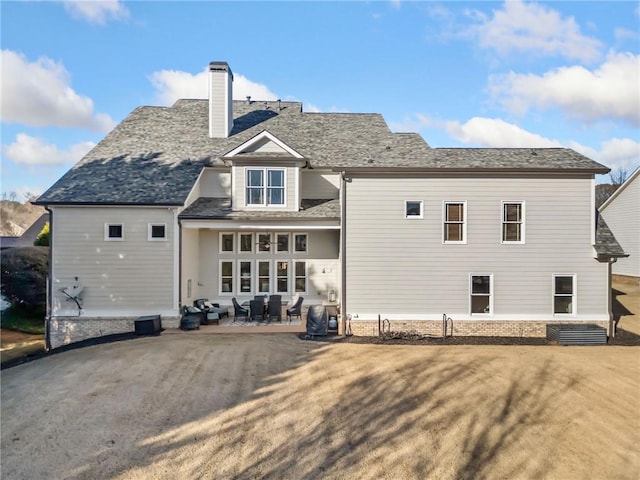 back of property with a yard and a patio