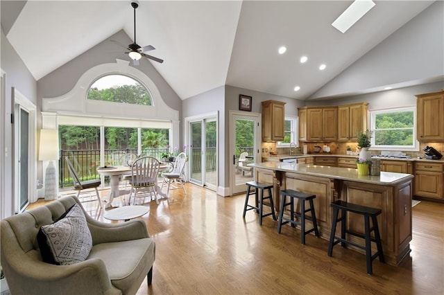 2675 Portabella Ln, Cumming, GA 30041 - kitchen with high vaulted ceiling, ceiling fan, a kitchen breakfast bar, a kitchen island, and tasteful backsplash