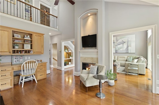 2675 Portabella Ln, Cumming, GA 30041 - living room with a ceiling fan, dark wood-style floors, a high end fireplace, built in shelves, and a towering ceiling
