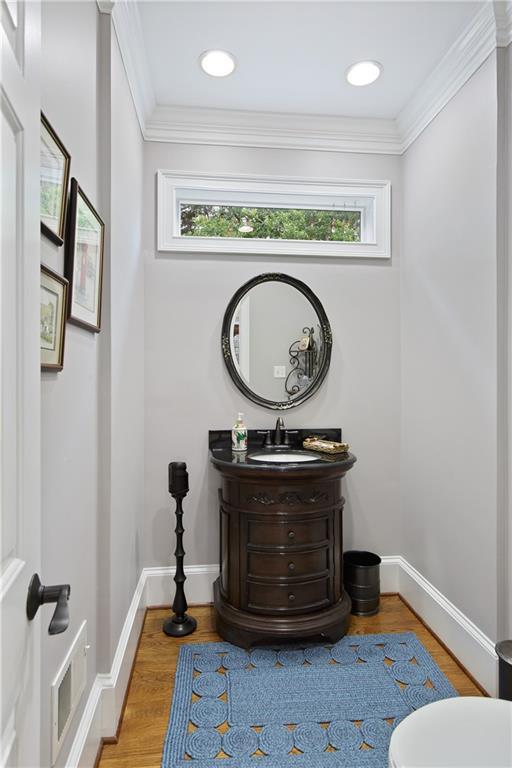 2675 Portabella Ln, Cumming, GA 30041 - bathroom with plenty of natural light, vanity, baseboards, wood finished floors, and ornamental molding