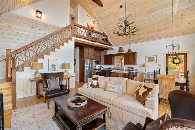 living room featuring light wood-type flooring, an inviting chandelier, high vaulted ceiling, sink, and wooden ceiling