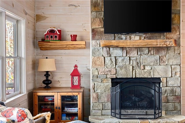 room details featuring a stone fireplace and wooden walls