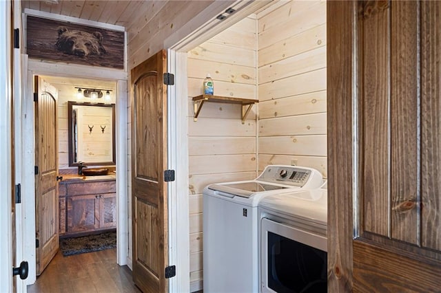 washroom with dark hardwood / wood-style floors, washer and clothes dryer, wood walls, and wood ceiling