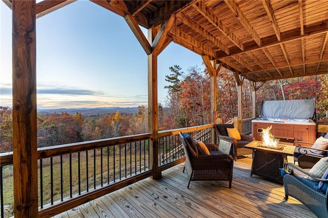 deck at dusk featuring an outdoor fire pit