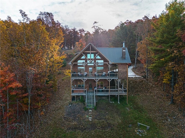 rear view of property featuring a deck and a balcony