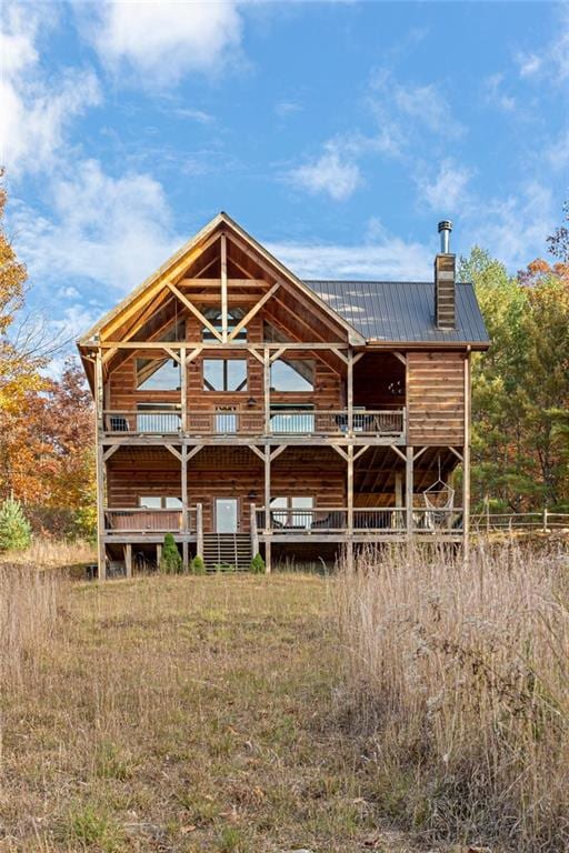 rear view of property featuring a wooden deck