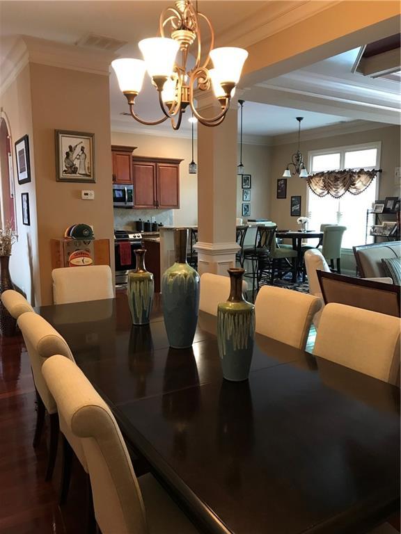 1175 Grassy Oat Ln, Lawrenceville, GA 30045 - dining space with a chandelier, crown molding, and dark wood-style floors