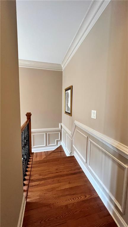1175 Grassy Oat Ln, Lawrenceville, GA 30045 - corridor with ornamental molding, a decorative wall, an upstairs landing, wood finished floors, and a wainscoted wall