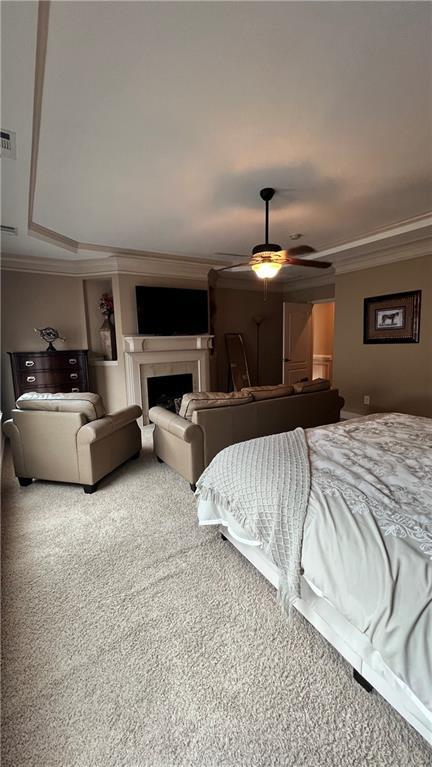 1175 Grassy Oat Ln, Lawrenceville, GA 30045 - bedroom featuring ornamental molding, a fireplace, carpet floors, and a ceiling fan