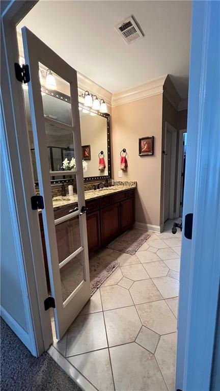 1175 Grassy Oat Ln, Lawrenceville, GA 30045 - bathroom with vanity, crown molding, and tile patterned flooring