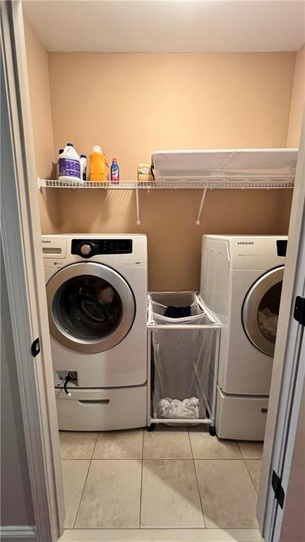 1175 Grassy Oat Ln, Lawrenceville, GA 30045 - laundry area with light tile patterned floors and washer and clothes dryer