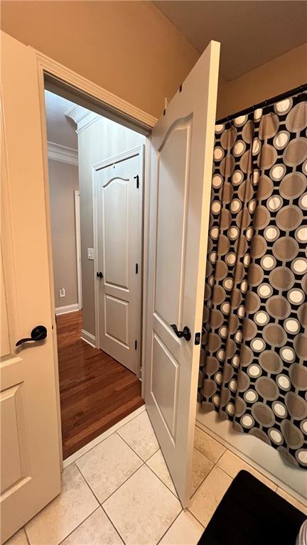 1175 Grassy Oat Ln, Lawrenceville, GA 30045 - bathroom featuring tile patterned floors, ornamental molding, and curtained shower