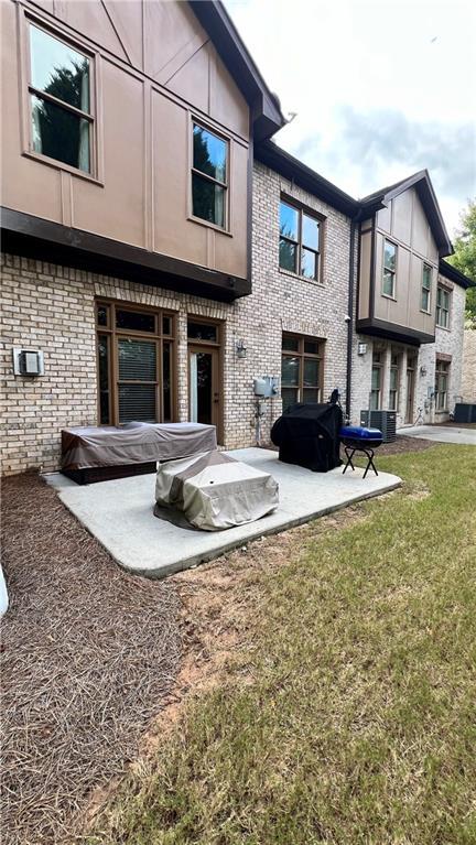 1175 Grassy Oat Ln, Lawrenceville, GA 30045 - back of property with brick siding, a patio area, and a yard