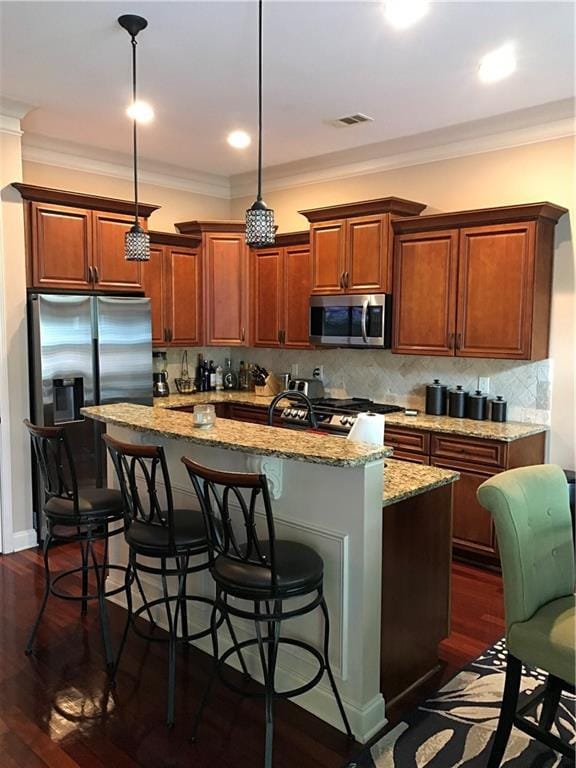 1175 Grassy Oat Ln, Lawrenceville, GA 30045 - kitchen featuring stainless steel appliances, a kitchen island, light stone counters, ornamental molding, and a kitchen bar