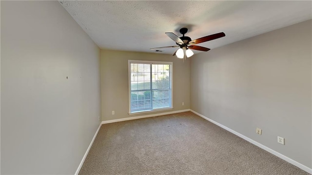 carpeted spare room featuring a ceiling fan, baseboards, and a textured ceiling