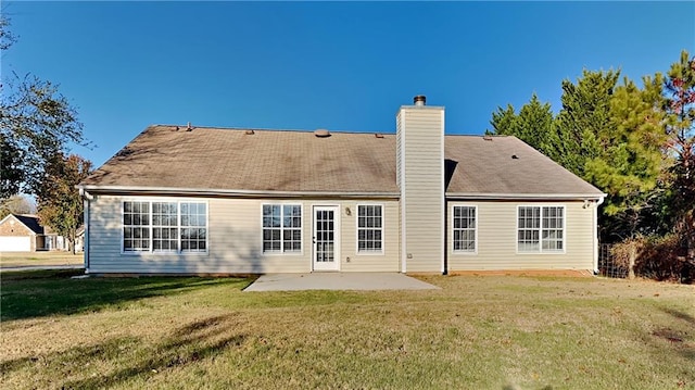 back of house featuring a patio area, a chimney, and a yard