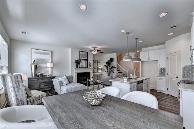 dining room featuring dark hardwood / wood-style flooring, ceiling fan, and sink