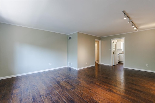 empty room featuring dark wood-type flooring, track lighting, and crown molding