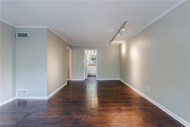 empty room featuring dark wood-type flooring, ornamental molding, and track lighting