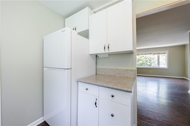 kitchen with white fridge, white cabinetry, and dark hardwood / wood-style flooring