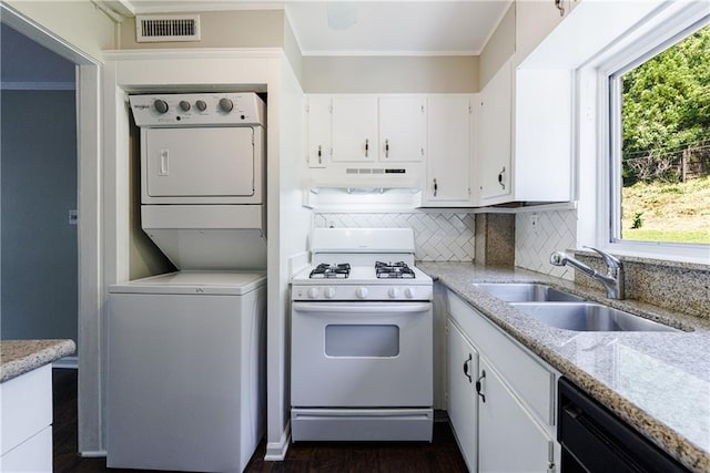 kitchen with dishwasher, white cabinetry, sink, stacked washer and clothes dryer, and white gas range oven