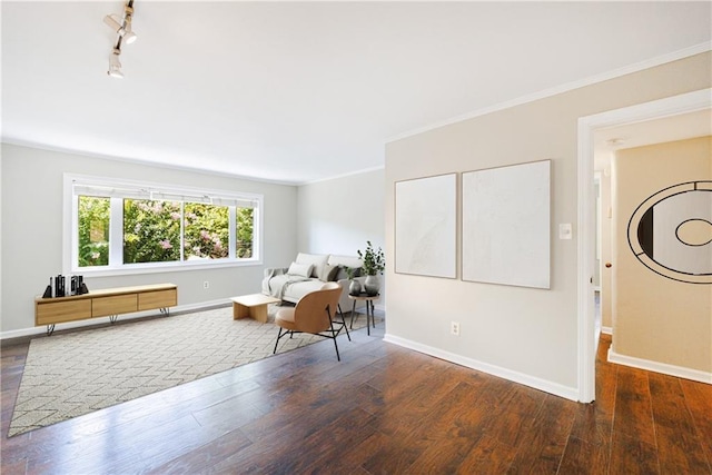 sitting room featuring rail lighting, dark hardwood / wood-style flooring, and ornamental molding