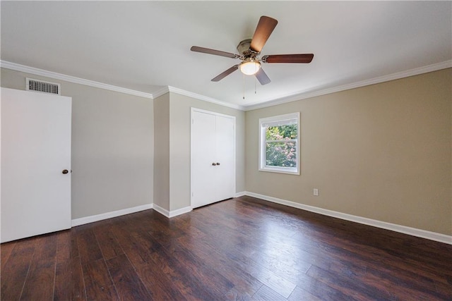 empty room with ceiling fan, dark hardwood / wood-style flooring, and ornamental molding