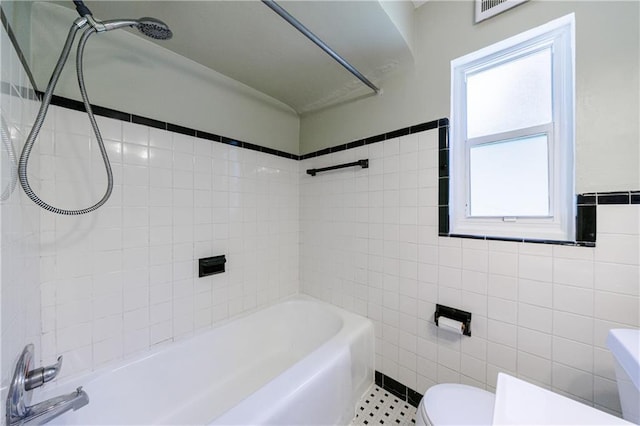 bathroom with tile patterned flooring, tile walls, and toilet