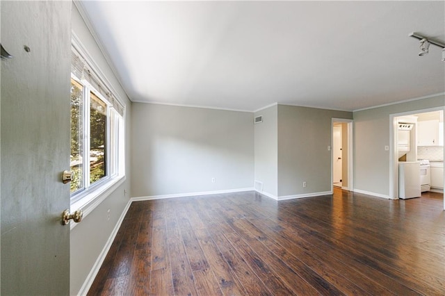 unfurnished living room with dark wood-type flooring, ornamental molding, and rail lighting