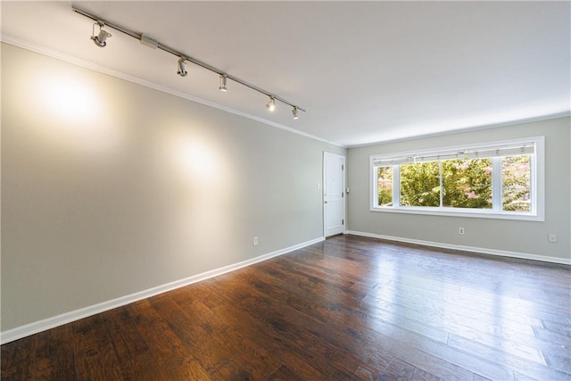 unfurnished room with dark wood-type flooring, ornamental molding, and rail lighting