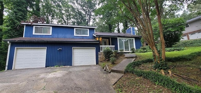 split level home featuring driveway, a chimney, and an attached garage