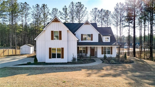 modern farmhouse featuring a porch, a storage unit, and a front yard