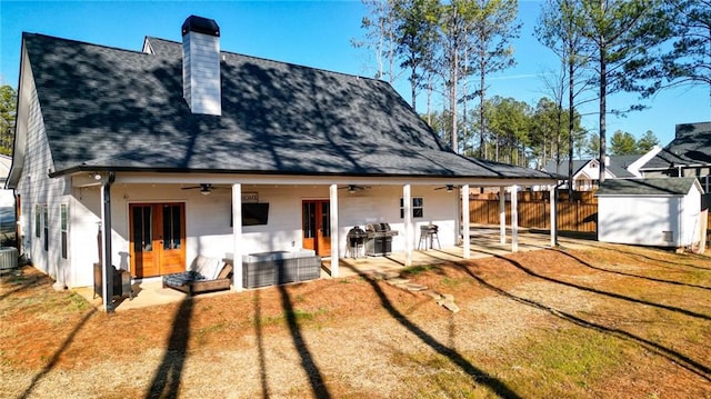 rear view of property featuring a patio, a lawn, cooling unit, ceiling fan, and french doors