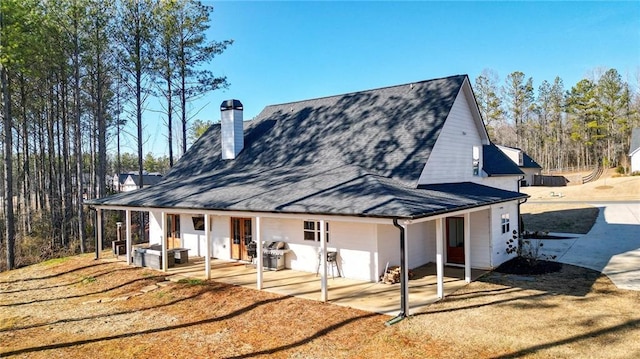 rear view of house with a patio and a yard