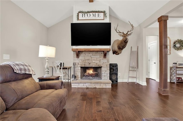 living room with lofted ceiling, a stone fireplace, decorative columns, and dark hardwood / wood-style floors