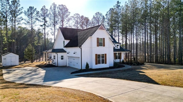 view of side of property with a storage shed, a garage, and a lawn