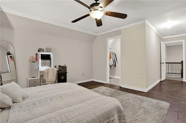 bedroom featuring dark hardwood / wood-style floors, lofted ceiling, ornamental molding, a spacious closet, and ceiling fan