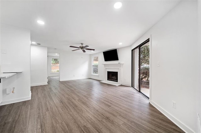 1379 Keys Lake Dr NE, Brookhaven, GA 30319 - unfurnished living room with a fireplace with raised hearth, ceiling fan, baseboards, recessed lighting, and wood finished floors