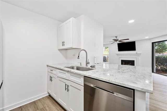 1379 Keys Lake Dr NE, Brookhaven, GA 30319 - kitchen with a sink, light stone counters, stainless steel dishwasher, a peninsula, and white cabinets