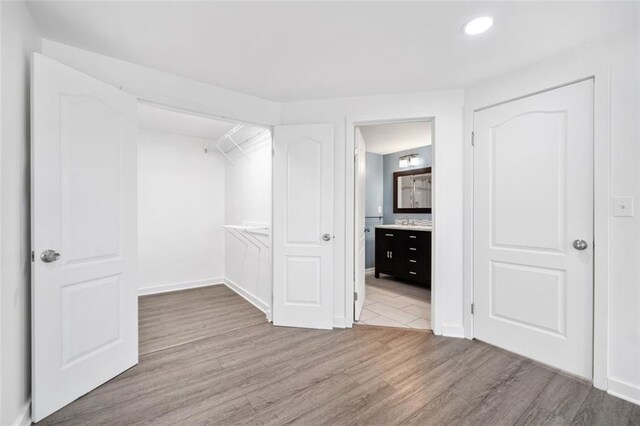 1379 Keys Lake Dr NE, Brookhaven, GA 30319 - unfurnished bedroom with connected bathroom, baseboards, and wood finished floors