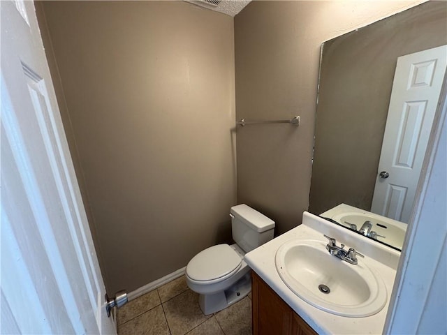 bathroom with tile patterned flooring, vanity, and toilet