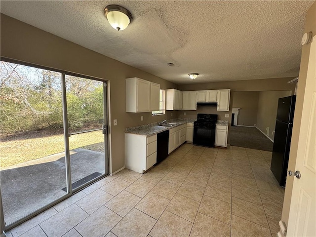 kitchen with white cabinetry, sink, light tile patterned floors, and black appliances