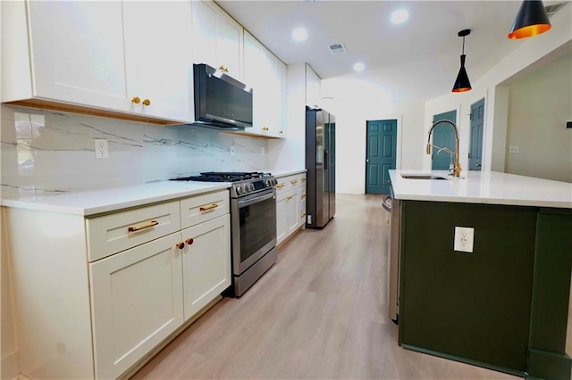 455 Saddle Bow Dr, Lawrenceville, GA 30046 - kitchen with appliances with stainless steel finishes, a sink, light wood-style floors, light countertops, and white cabinets