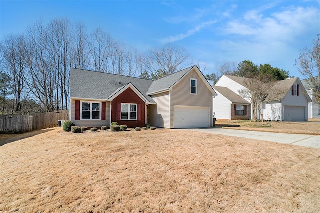 view of front facade featuring a garage, brick siding, fence, concrete driveway, and a front yard