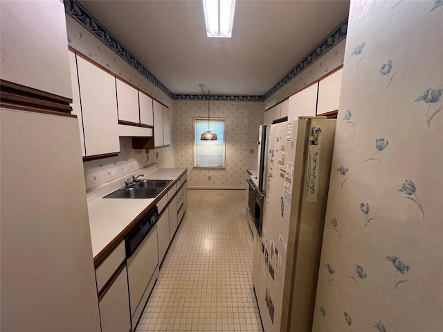 kitchen with a sink, white appliances, white cabinetry, and wallpapered walls